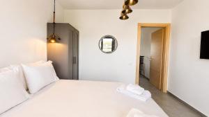 a bedroom with a large white bed and a mirror at Ambra Luxury Suite 14 in Kallithea Halkidikis