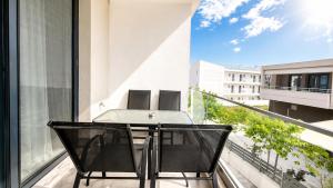 a table and chairs on the balcony of a building at Ambra Luxury Suite 14 in Kallithea Halkidikis