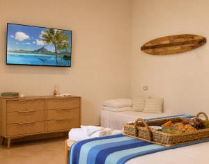 a bedroom with two beds and a tv on the wall at LIGEA APARTMENT - Bright Mediterranean Home with Bali-Inspired Touches - Central Anzio near Sea, Train and Bus Station in Anzio