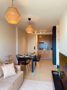 a living room with a couch and a dining room table at Apartamento Sofisticado com terraço centro Pouso Alegre in Pouso Alegre