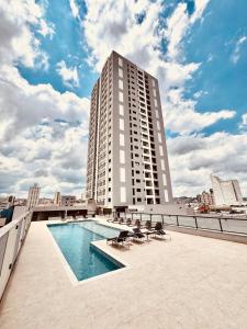 a large building with a swimming pool on a balcony at Apartamento Sofisticado com terraço centro Pouso Alegre in Pouso Alegre
