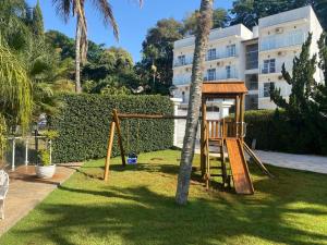 a playground in a yard next to a building at Hotel Beira Rio in Piraju