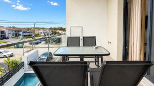 a table and chairs on a balcony with a view of a street at Ambra Luxury Suite 15 in Kallithea Halkidikis