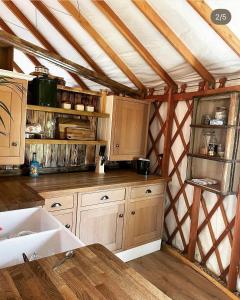 a kitchen with wooden cabinets and a counter top at Yurt - The Spinney in Faringdon