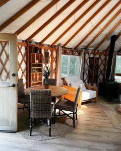 a room with a table and chairs in a yurt at Yurt - The Spinney in Faringdon
