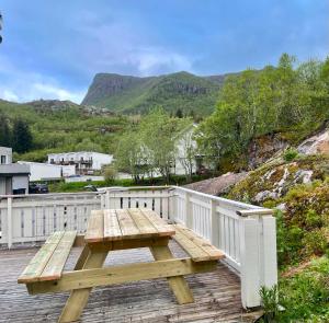 a wooden picnic table on a wooden deck with a fence at Svolvær Minihouse in Kongsmarka