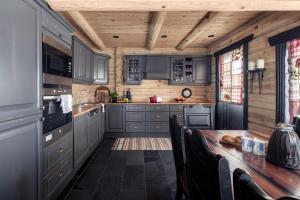 a kitchen with gray cabinets and a wooden table at Utsikten in Vågsli