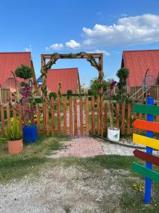 a wooden fence with a wooden arch in a yard at denizkızı bungalow in Zumrutkaya