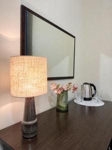 a table with a lamp and flowers on it at Alex Hotel in Odesa
