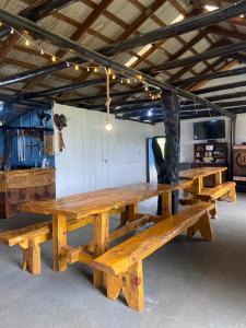 a group of wooden picnic tables in a building at Chácara Leopoldo Bairro in Lages