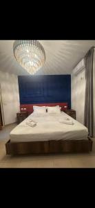 a bedroom with a large bed with a blue headboard at Hotel Liburnia Vitamin Aga in Golem