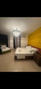 a bedroom with two beds and a chandelier at Hotel Liburnia Vitamin Aga in Golem +9 photos