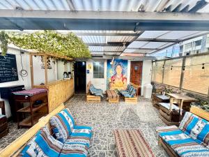 an outdoor patio with couches and chairs and a table at Cusco House Inn Hostel in Cusco