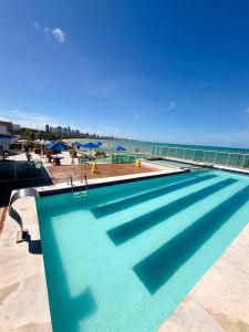 a swimming pool with a view of the ocean at Flat JP Beira mar in João Pessoa