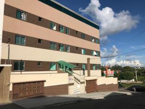 a tall building with a parking garage next to it at Ed Odilon Vieira 104 in Vitória da Conquista
