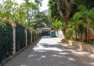 a walkway in a park with trees and flowers at The African Artisan 3BR Apartment in Nairobi