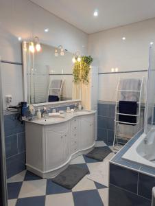 a bathroom with a sink and a mirror and a tub at Jardhelena in Jardin