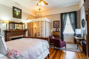 a bedroom with a bed and a desk and a window at The Reynolds Mansion in Asheville