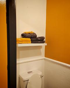a bathroom with a toilet and towels on a shelf at Phoenix in Derry Londonderry