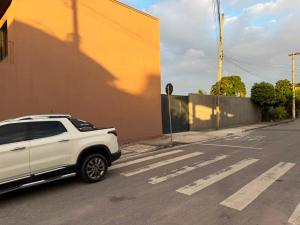 a white truck parked on the side of a street at Hotel Betel 3 pontes in Itaboraí