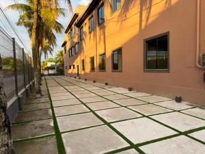 an empty sidewalk next to a building with a palm tree at Hotel Betel 3 pontes in Itaboraí