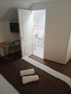 a bedroom with a bed with two towels on it at Casa Barry's in Tăşnad