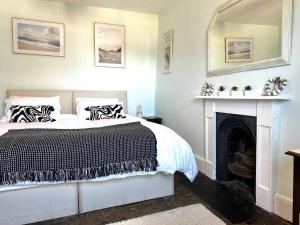 a bedroom with a bed and a fireplace at Glanrafon in Llwyngwril