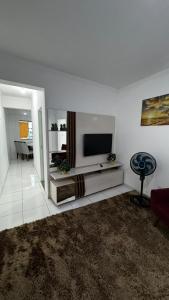 a living room with a flat screen tv on a white wall at Ed. Odilon Vieira ap.205 in Vitória da Conquista