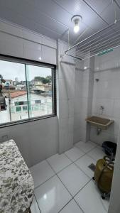 a white bathroom with a sink and a window at Ed. Odilon Vieira ap.205 in Vitória da Conquista +8 photos