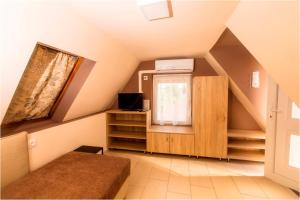 a attic room with a bed and a window at Róma Apartmanház in Bogács