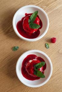 two white bowls of raspberry sauce with mint on a table at Chambres d'hôtes "Chez Lyly et Juju" Piscine&Sauna Parking Gratuit in Angers
