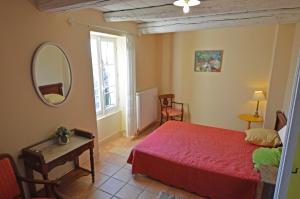 ラ・ガルド・アデマールにあるMas Antoninのベッドルーム(赤いベッド1台、鏡付)