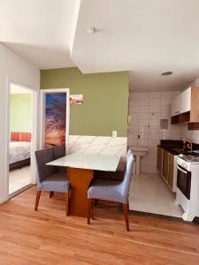 a kitchen and dining room with a table and chairs at Frente Mar Green Diamond Residencial in Vila Velha