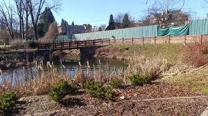 a bridge over a river with a fence at Na břehu Olše in Český Těšín +5 photos