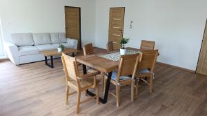 a dining room with a table and chairs and a couch at Na břehu Olše in Český Těšín