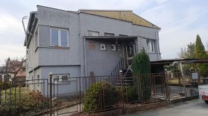 a gray house with a fence in front of it at Na břehu Olše in Český Těšín