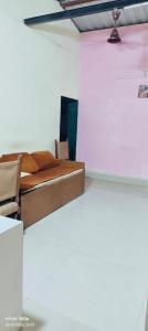 a room with a bed and chairs in it at Peaceful Stay in Malvan