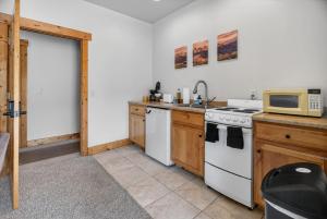 a kitchen with a stove and a microwave at 1BR Mountain View Studio with Fireplace Deck Views in Fort Collins