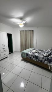 a bedroom with a bed sitting on a tiled floor at Ed Odilon Vieira 304 in Vitória da Conquista