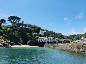 a view of a beach and houses on a hill at Forge Cottage in Polperro