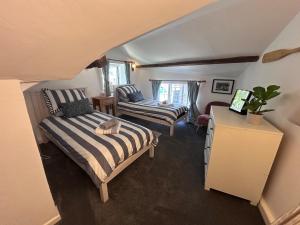a small bedroom with a bed and a chair at Forge Cottage in Polperro