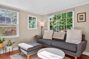a living room with a couch and a table and windows at The McKinley Cottage in Boise