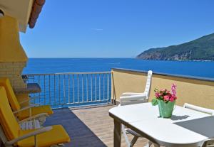 Un balcón con mesa y sillas y el mar. en House Maestrale by Holiday World, en Moneglia