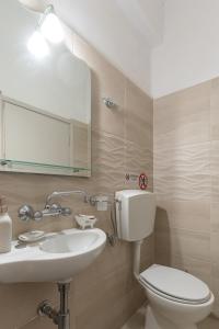 a bathroom with a toilet and a sink and a mirror at Tsimiklis Apartments in Finikounta +55 photos