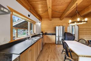 a kitchen with a dining table and a refrigerator at Cabin on Private 8-acre Lake in Clearwater +7 photos