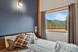 a bedroom with a bed and a large window at Cabin on Private 8-acre Lake in Clearwater
