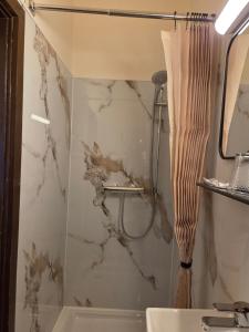 a bathroom with a marble shower curtain and a sink at Pension Grum in Arnoldstein +34 photos