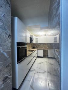 a kitchen with white cabinets and a refrigerator at Das gemütliche Unterkunft in Gelsenkirchen