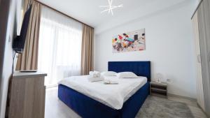 a bedroom with a blue and white bed and a window at Summerland Sea & Lake in Mamaia +38 photos