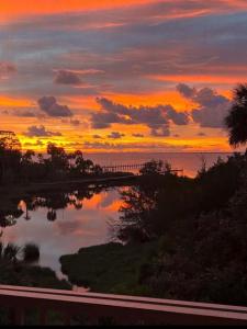 a sunset over a body of water with a road at St George Island Bay Front Pool in St. George Island